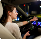 A woman drives a vehicle at night. 